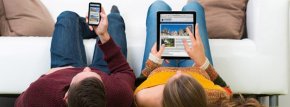 Breitband ein Mann und eine Frau schauen auf ihr Handy und auf ihr Tablet