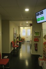 Wartebereich Bürgerbüro Ein Gang mit leeren Stühlen und Fernsehmonitor