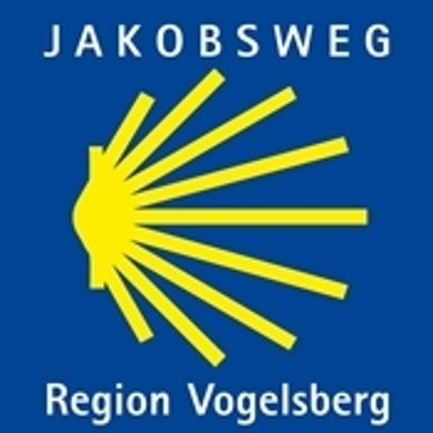 Markierung Jakobsweg gelbe Muschel auf blauem Grund