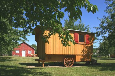Schäferwagen und rotes Service-Holzhaus