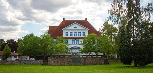Kulturzentrum Alte Grundschule Frontansicht durch die Bäume am Bürgerpark