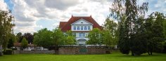 Kulturzentrum Alte Grundschule Frontansicht durch die Bäume am Bürgerpark