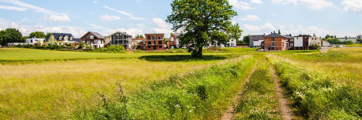 Felder, Wiesen und neugebaute Einfamilienhäuser