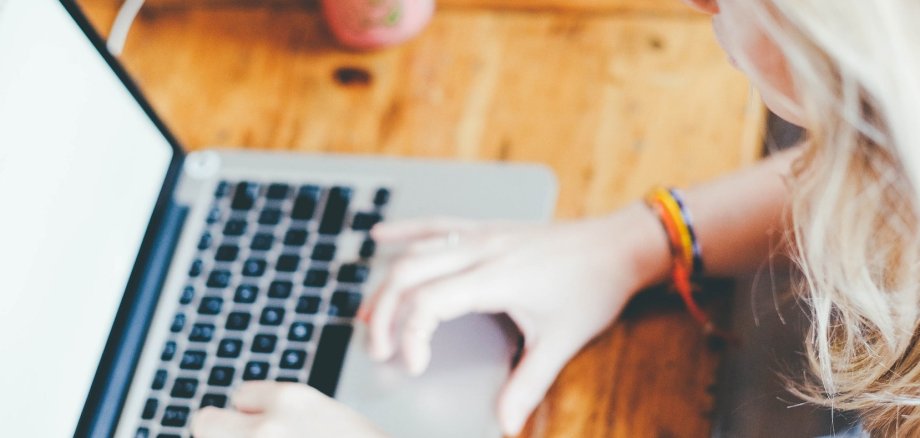 Laptop und Hand, die etwas eintippt