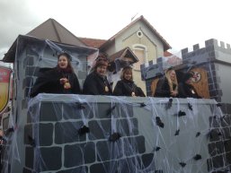 Faschingswagen dekoriert mit Burganlage, Spinnweben und Fledermäusen, darauf kostümierte Frauen des Carnevalclubs Bellersheim