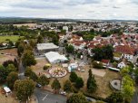 Luftbild, Ausschnitt einer Kleinstadt, davor Festplatz mit Festzelt, Karussell und Buden