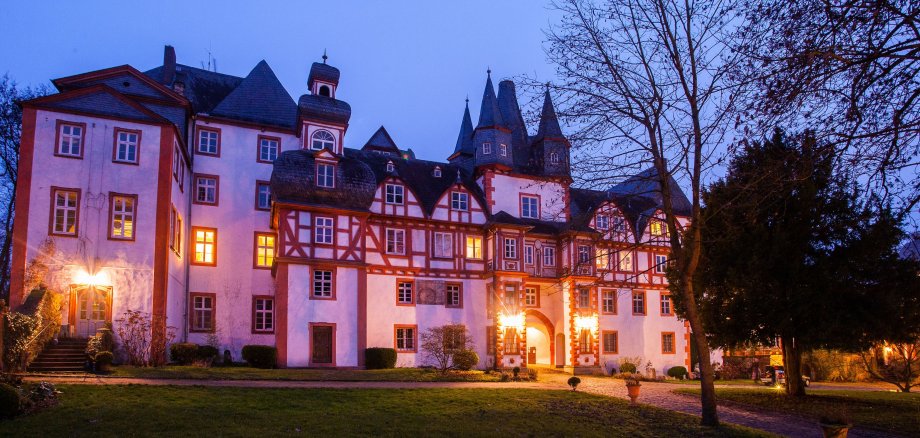 Die beleuchtete Fachwerkfassade von Schloss Hungen bei Nacht