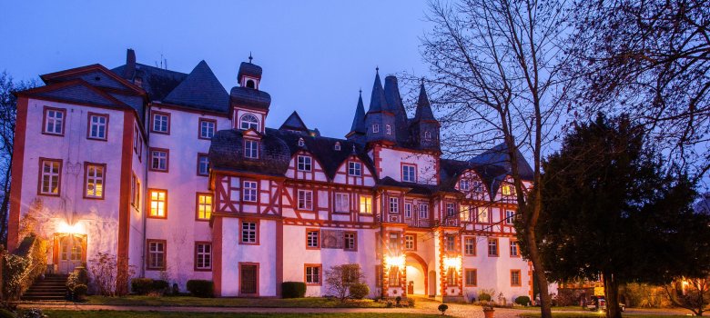 Die beleuchtete Fachwerkfassade von Schloss Hungen bei Nacht