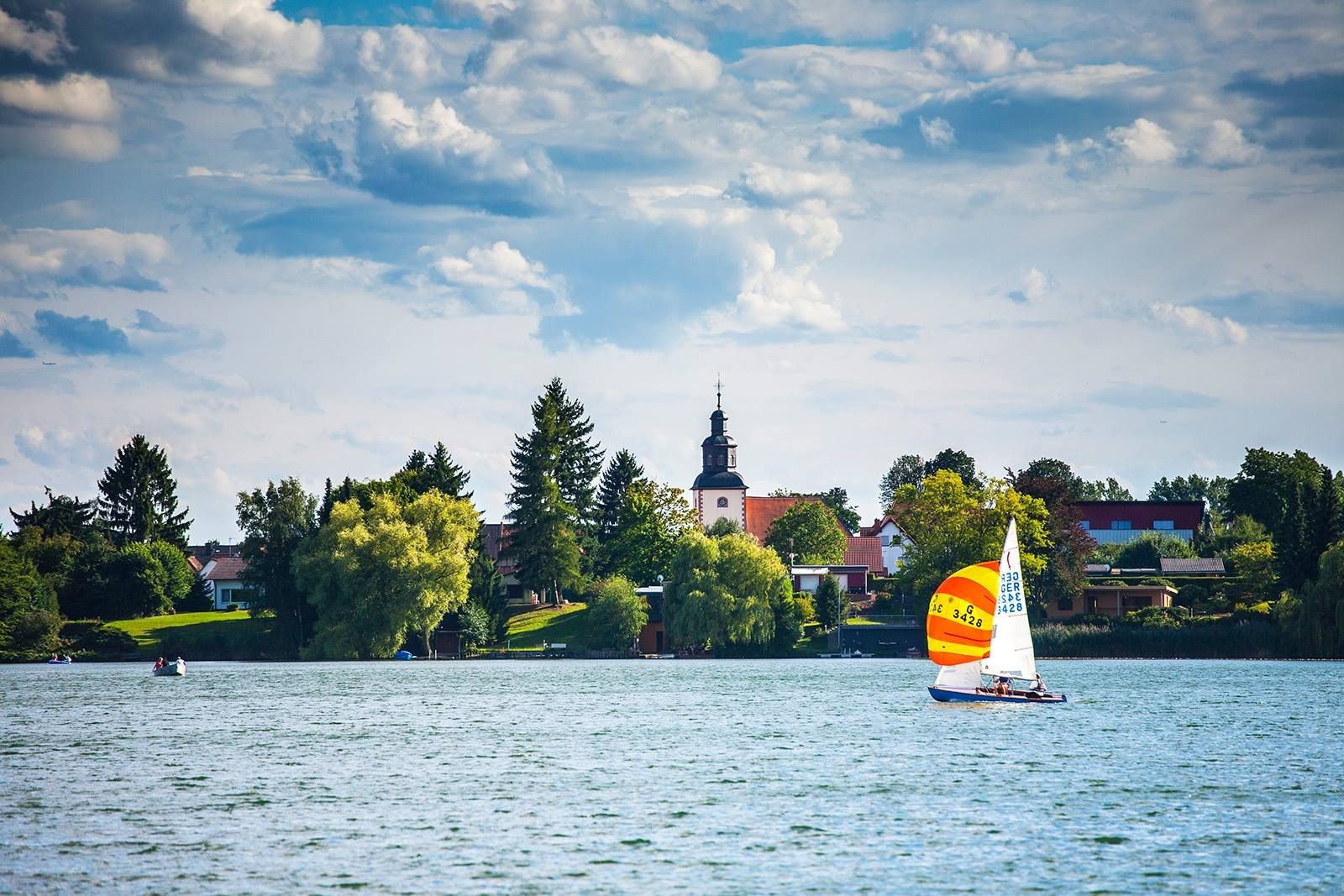 Inheidener / Trais Horloffer See mit Segelboot Segeler auf dem See, im Hintergrund Kirchturm Trais Horloff